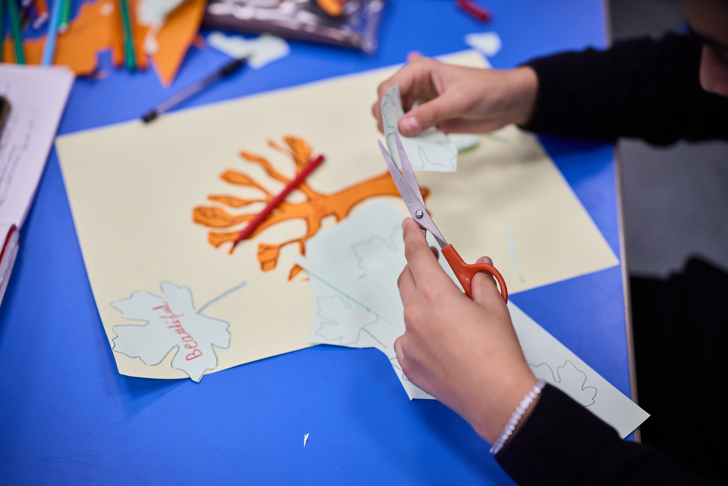 pupil cutting paper in craft class